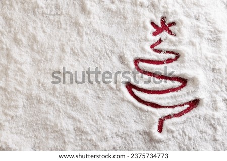 Christmas tree drawn in snow and copy space on red background. Christmas, decorations, tradition and celebration concept.