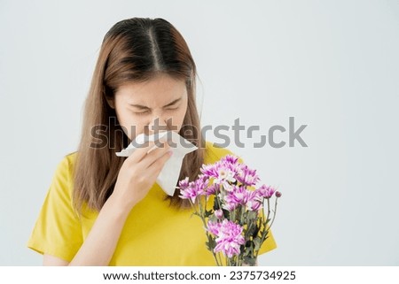 Pollen Allergies, asian young woman sneezing in a handkerchief or blowing in a wipe, allergic to wild spring flowers or blossoms during spring. allergic reaction, respiratory system problems Royalty-Free Stock Photo #2375734925