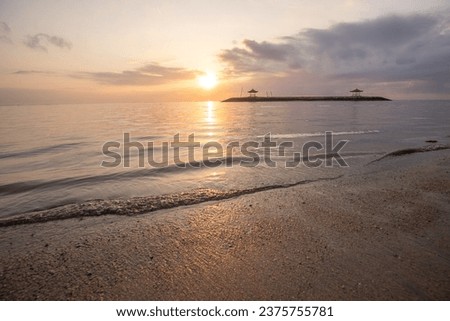 Landscape shot in Bali. Sunrise or sunset at Sanur beach. Beautiful sandy beach in the morning, with fine sand and a view of the calm sea. Temples are in the water. A dream in Indonesia Royalty-Free Stock Photo #2375755781