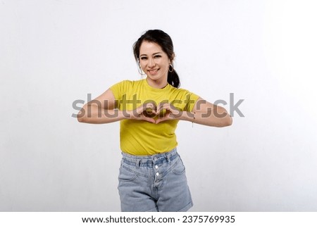 Happy Beautiful Asian women wear colorful shirt making a hands sign in hearth shape isolated on white background