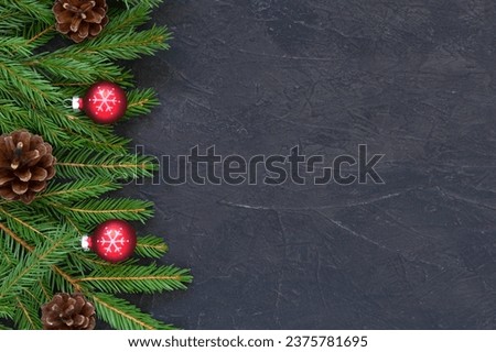 Christmas or New Year background 2025 with Christmas tree branches dark background  red glass balls decoration, fir branches. Top view  copy space