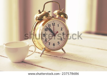 Image of coffee cup and gold alarm clock