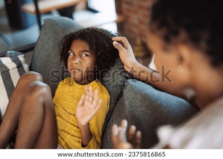 Single African American mother consoling her angry daughter who refusing to listen to her Royalty-Free Stock Photo #2375816865