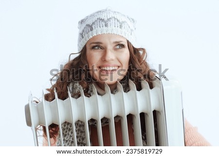 Hello winter. happy trendy woman in sweater, mittens, hat and scarf isolated on white background with heater.