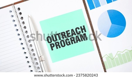 Green card on the white notepad. Text OUTREACH PROGRAM. Business concept Royalty-Free Stock Photo #2375820243