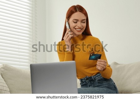 Happy woman with credit card using smartphone for online shopping at home