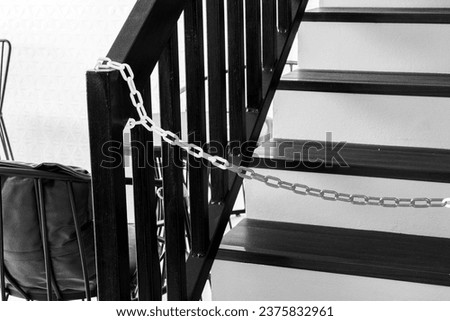 Plastic red and white warning chain links and wooden stair.