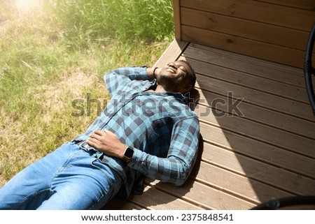 Happy male relaxing on a wooden terrace Royalty-Free Stock Photo #2375848541