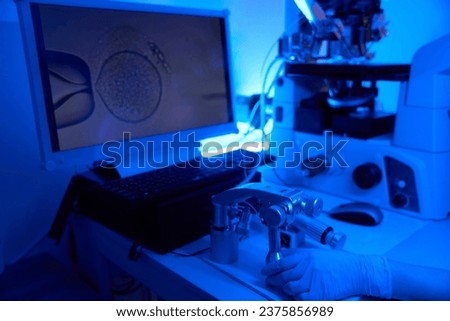Embryologist carrying out intracytoplasmic sperm injection displayed on monitor Royalty-Free Stock Photo #2375856989