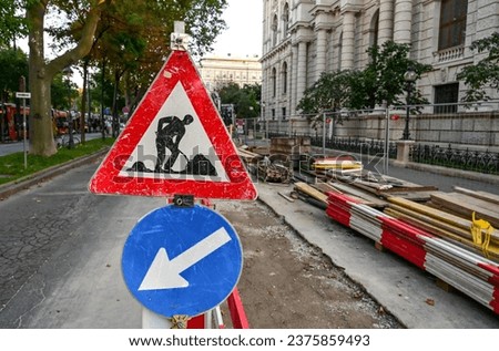 Road works traffic sign. Repairing street and sidewalk in city street. Under construction sign by road.  Symbol of Men at work. 
