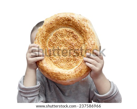 cute boy holding Uzbek bread on a white background