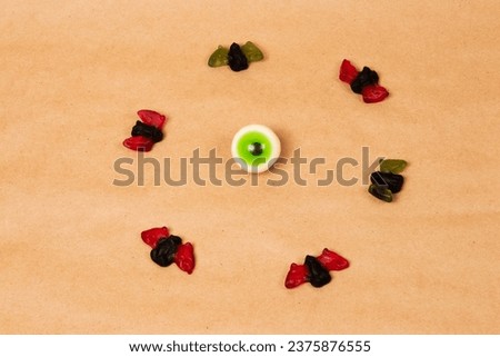Halloween party candy decoration background. Green candy eye and gummy bats.