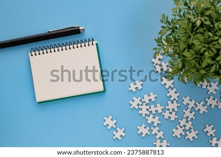 There is a blanc notebook with peaces of puzzle.