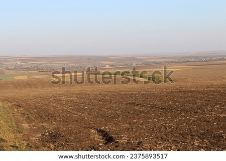 A large field with a small village in the distance