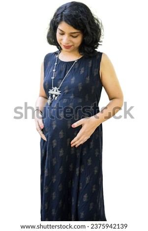 A pregnant Indian lady poses for pregnancy shoot and hands on belly with white background, Indian pregnant woman puts her hand on her stomach in maternity dress with plain background, Pregnancy shoot