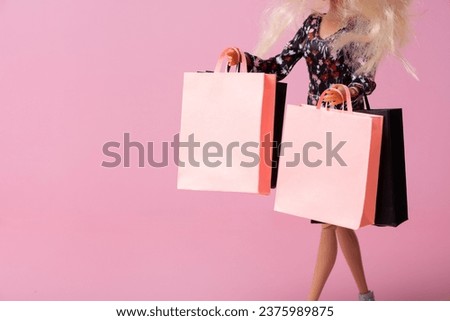 Sale, black friday concept. A doll with shopping packages in her hands