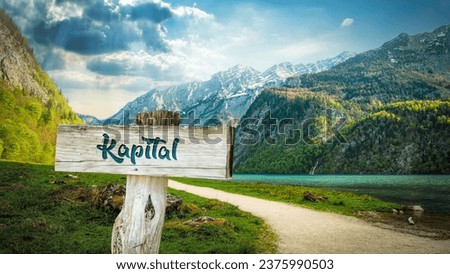 Picture shows a signpost and a sign pointing in German towards the capital.