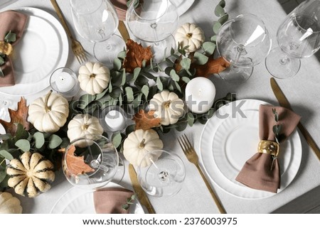 Beautiful autumn table setting. Plates, cutlery, glasses, pumpkins and floral decor, flat lay Royalty-Free Stock Photo #2376003975