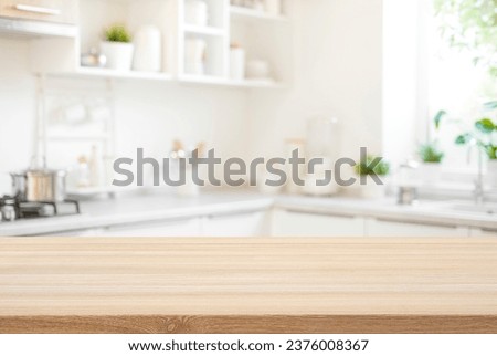 Wooden table top view for product montage over blurred kitchen interior background Royalty-Free Stock Photo #2376008367