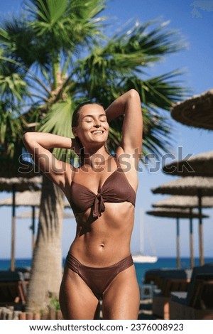 Young and beautiful woman sunbathing after swimming in sea during her summer vacation