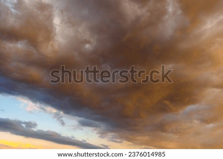 Partly cloudy sky low angle view. Dramatic clouds at sunset or sunrise background photo. Royalty-Free Stock Photo #2376014985