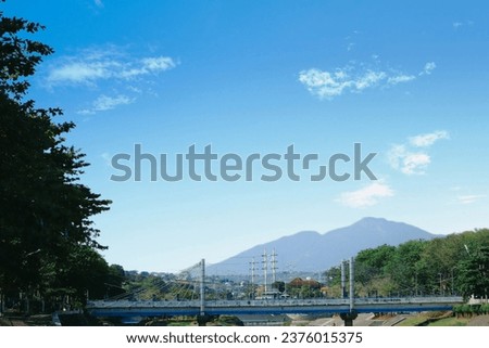 The West Canal flood bridge is located in the city of Semarang with a view of Mount Ungaran as a backdrop.