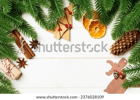 Top view of fir tree branches and festive decorative toys on wooden background. New Year time concept with empty space for your design.