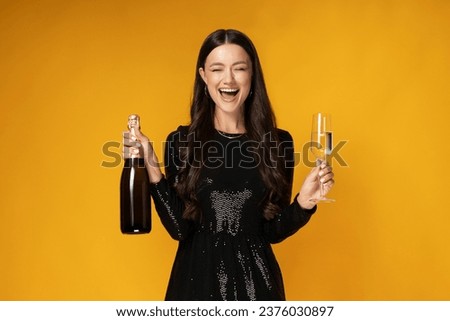 Girl with champagne and glasses on a yellow background.