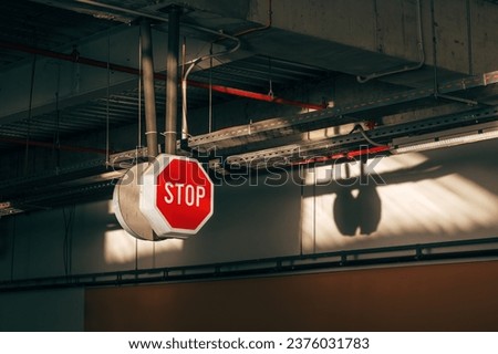 Stop sign in underground garage of shopping mall, selective focus