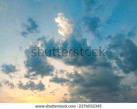 Rainy clouds spreading on the blue sky background. Multitude clouds in evening sunset. Large soft black clouds. Nature concept background. Thick clouds background. Horizontal landscape image