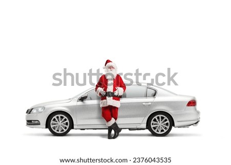 Santa claus leaning on a silver car isolated on white background