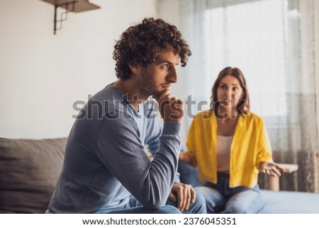 Man and woman are sitting at sofa and arguing. Relationship problems. Royalty-Free Stock Photo #2376045351