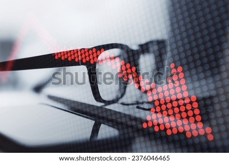 Close up of laptop and glasses with creative downward red pixel arrow on blurry background. Double exposure