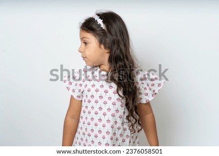 Close up side profile photo beautiful kid girl wearing polka dot dress not smiling attentive listen concentrated