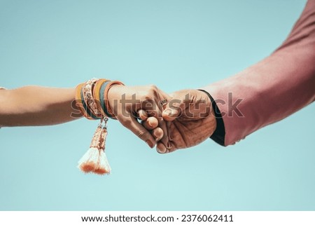 Multiracial couple holding hands together in love. Conceptual image of world unity interracial love and understanding in tolerance and diversity.
