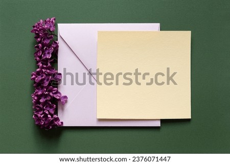 Happy birthday, Valentine's day, Easter, mother's day, wedding composition. Blank greeting card, invitation and envelope mockup. Square blank with delicate lilac flowers. Flat lay, top view.