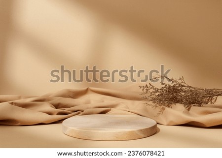 Circle wooden product placement podium with dried plant, shadow on brown background