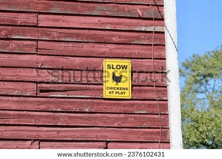 A yellow sign warning people to slow down for the chickens.