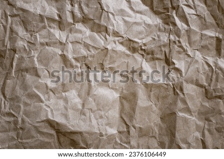 Sheet of crumpled kraft paper in brown color, background, texture, cellulose recycling, waste paper concept. Unbleached plain wrapping paper. Eco-friendly Biodegradable Kraft Wrapping Paper