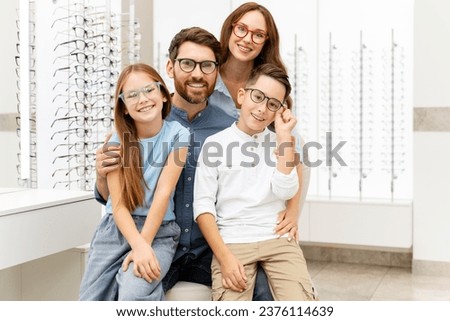 Portrait of young happy family wearing stylish eyeglasses sitting in  optical store. Vision concept  Royalty-Free Stock Photo #2376114639