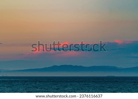 Crimson background clouds with ocean horizon in interesting color shades as a backgrounds, screensaver, blank, abstract photo for relaxation, reflection on being and life in this world.