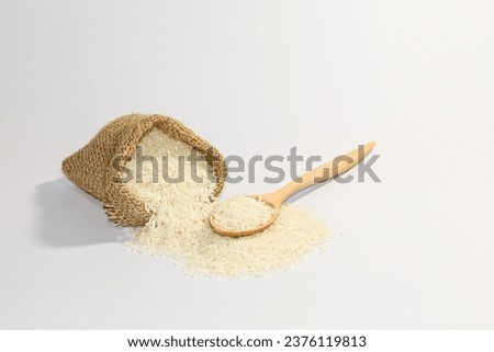 White rice spread out of the sack in white background with isolated picture style.Thailand jasmine rice. Royalty-Free Stock Photo #2376119813