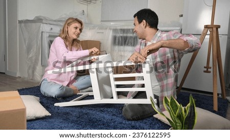 Love couple assembly new home ikea furniture. Family moving into house. Joyful guy buy hand made chair. Girl sit floor. People do kitchen renovation. Man rent flat. Team work craft diy. Manual repair. Royalty-Free Stock Photo #2376122595