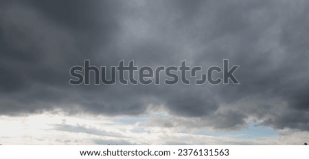 Autumn brings overcast skies adorned with gray stratus clouds, hinting at impending rain. This full-screen view provides ample space for text or design elements, making it perfect for various projects Royalty-Free Stock Photo #2376131563