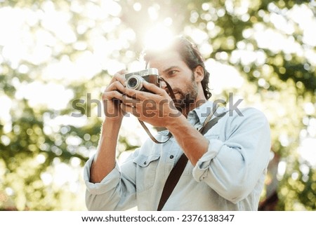 Picture, photographer or man in park on holiday vacation trip for creativity, shooting or tourism memory. Photography, travel or male tourist with camera for sightseeing or trees in nature in summer
