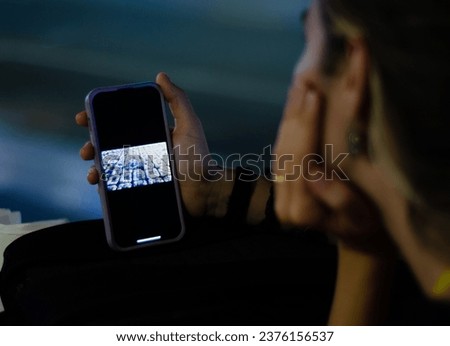 Young woman looking at photographs on her mobile smartphone dreaming about her next vacation trip.