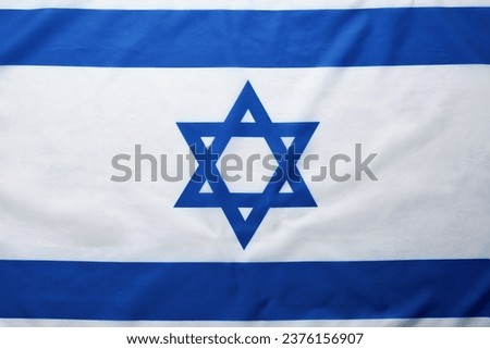 Israel flag. Independence Day of Israel. Israel flag beautifully waving wave with star of David over white wooden background. National pride of Israel. Patriotism and commonwealth. Top view. Mock up. Royalty-Free Stock Photo #2376156907
