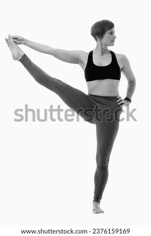 Utthita hasta padangusthasana (Extended hand to big toe pose 2), Ashtanga yoga  Woman wearing sportswear doing Yoga exercise against white background.  Black and white image.