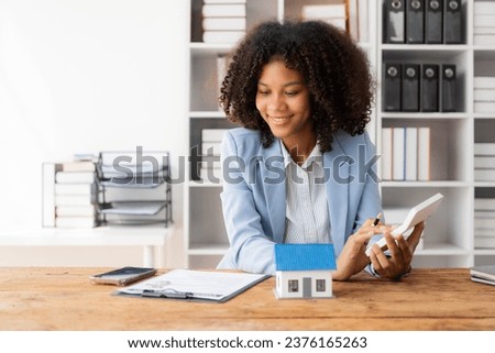 African American girl holds pen to read agreement document to sign land loan with real estate agent or bank teller, insurance concept