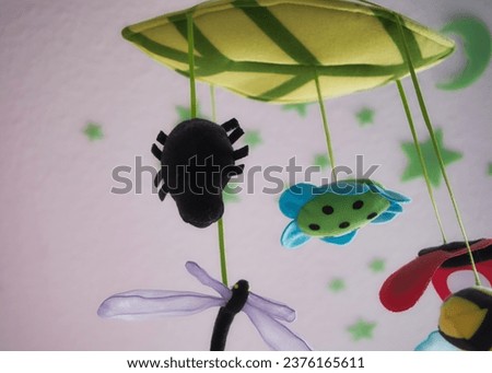 A close-up captures a children's mobile hanging from the ceiling of a nursery. The lovingly crafted figures float gently, creating a playful atmosphere. Royalty-Free Stock Photo #2376165611